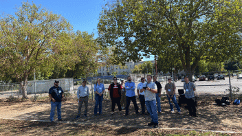 group of people on a field with a drone above them