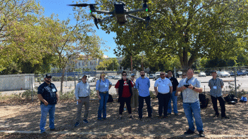 group of people on a field with a drone above them
